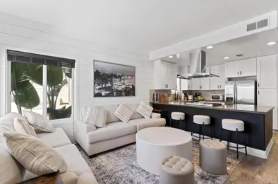 a living room with a couch and a kitchen at 4 Car Parking Steps 2 Lido Village Marina Phenomenal Location in Newport Beach