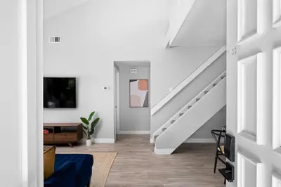 a white hallway with a staircase and a living room at Lux Modern Pet Friendly | Pool | Hot Tub | Tennis in Oceanside