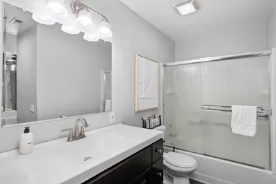 a bathroom with a sink and a toilet and a mirror at Lux Modern Pet Friendly | Pool | Hot Tub | Tennis in Oceanside