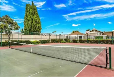a tennis court with a net on a court at Lux Modern Pet Friendly | Pool | Hot Tub | Tennis in Oceanside