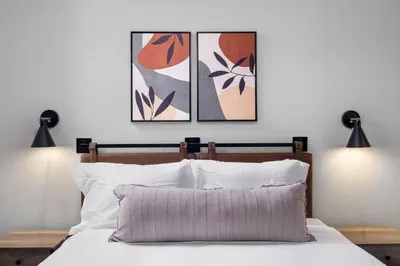 a bedroom with three paintings on the wall and a bed at Lux Modern Pet Friendly | Pool | Hot Tub | Tennis in Oceanside