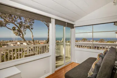 a living room with a couch and large windows at Seaview craftsman with Amazing views in San Diego