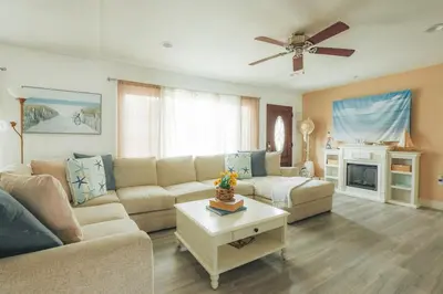 a living room with a couch and a ceiling fan at Coastal Chill San Diego - Heated Pool - XXL Spa - Mini Golf - Gourmet Kitchen in San Diego