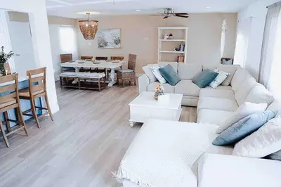 a living room with a white couch and a table at Coastal Chill San Diego - Heated Pool - XXL Spa - Mini Golf - Gourmet Kitchen in San Diego