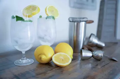 a wooden table with lemons and two glasses of lemonade at Coastal Chill San Diego - Heated Pool - XXL Spa - Mini Golf - Gourmet Kitchen in San Diego