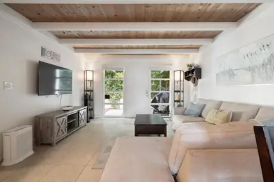 a living room with a couch and a tv at Heart of La Jolla Village cottage in San Diego