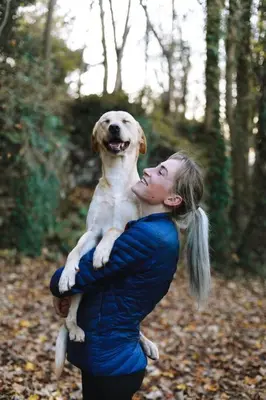 a woman holding a dog on her arms at Heart of San Diego-Walk Score 82-Backyard -BBQ-HBO in San Diego