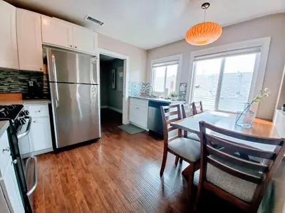 a kitchen with a table and a stainless steel refrigerator at Heart of San Diego-Walk Score 82-Backyard -BBQ-HBO in San Diego