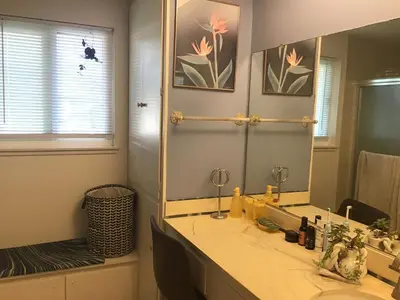 a bathroom with a sink and a large mirror at Guest Suites in High Tech Park in Rancho Bernardo