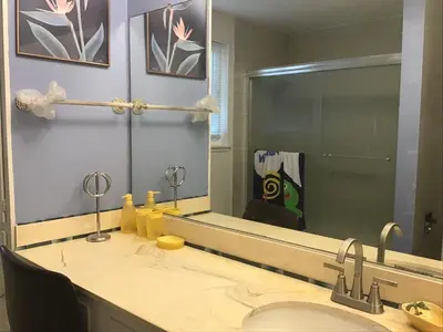 a bathroom with a sink and a large mirror at Guest Suites in High Tech Park in Rancho Bernardo