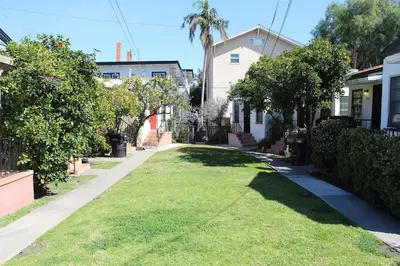 a house with a yard of grass and trees at Sweet n Cozy Cottage near Little Italy & Gaslamp in San Diego