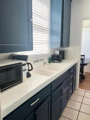 a kitchen with a sink and a microwave at Sweet n Cozy Cottage near Little Italy & Gaslamp in San Diego