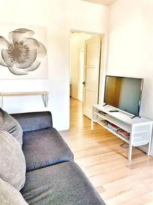 a living room with a couch and a flat screen tv at Sweet n Cozy Cottage near Little Italy & Gaslamp in San Diego