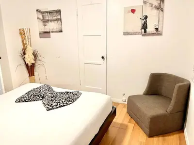 a bedroom with a bed and a chair in it at Cozy Urban Cottage in San Diego