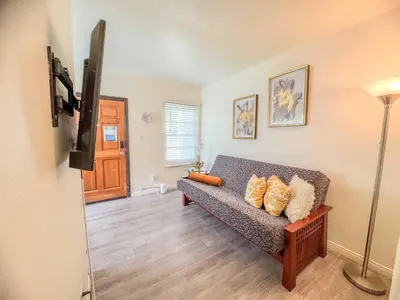 a living room with a couch and a television at Orange Grove Cottage in Bankers Hill in San Diego
