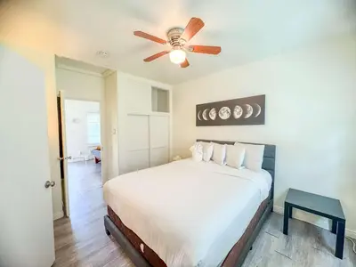 a bedroom with a bed with a ceiling fan at Orange Grove Cottage in Bankers Hill in San Diego