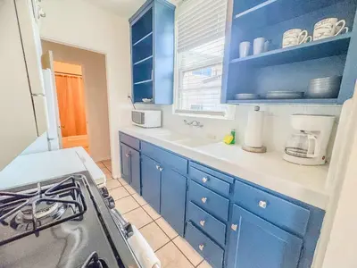 a kitchen with blue cabinets and a stove at Orange Grove Cottage in Bankers Hill in San Diego