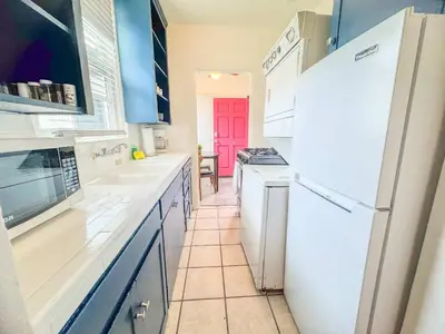 a kitchen with white appliances and a red door at Orange Grove Cottage in Bankers Hill in San Diego