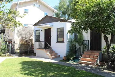 a white house with a gate and stairs in a yard at Amazing Cottage - near Little Italy Gaslamp in San Diego