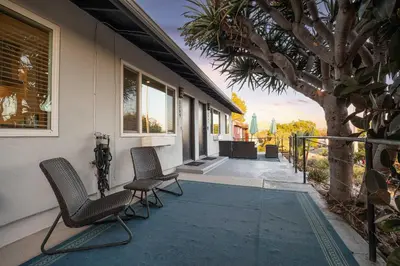 a porch with two chairs and a tree on a house at Central Location Balboa Park Villa in San Diego