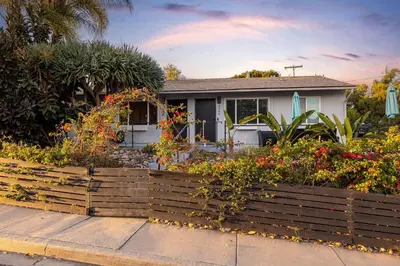 a house with a fence and flowers in front of it at Central Location Balboa Park Villa in San Diego