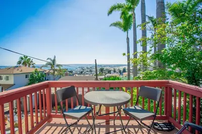a table and chairs on a balcony with palm trees at Great Views Studio apartment near Little Italy in San Diego
