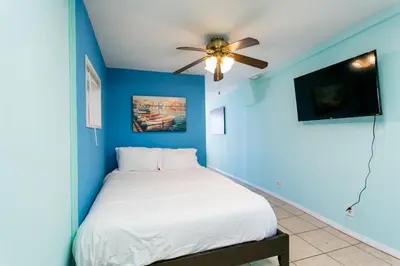 a blue bedroom with a bed with a ceiling fan at Great Views Studio apartment near Little Italy in San Diego
