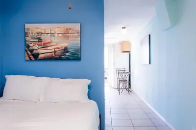 a blue bedroom with a bed and a painting of a boat at Great Views Studio apartment near Little Italy in San Diego