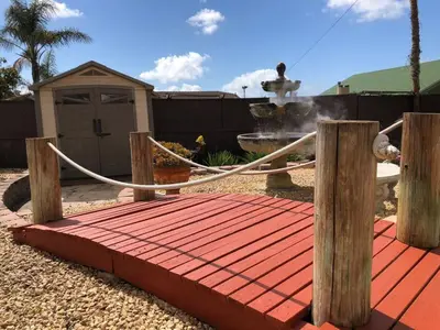 a wooden bridge with a fountain in a yard at Great Views Studio apartment near Little Italy in San Diego