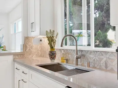 a white kitchen with a sink and a window at Lovely Laguna Oceanside Gem! in Laguna Beach