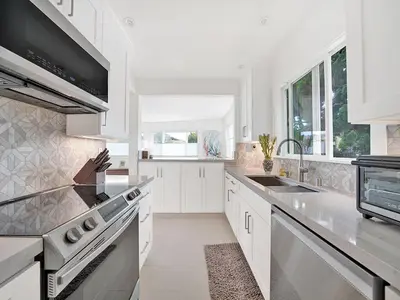 a white kitchen with a sink and a stove at Lovely Laguna Oceanside Gem! in Laguna Beach