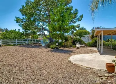 a gravel yard with a tree and a fence at Guest Suite Northern San Diego Great Price in Rancho Bernardo
