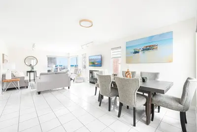 a dining room and living room with a table and chairs at Luxury 4Br W Ac, Rooftop Deck, And Stunning Ocean Views By Beachview Rentals in Newport Beach