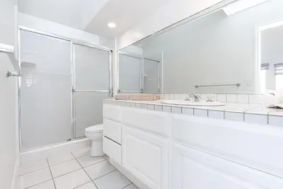 a white bathroom with a toilet and a sink at Luxury 4Br W Ac, Rooftop Deck, And Stunning Ocean Views By Beachview Rentals in Newport Beach