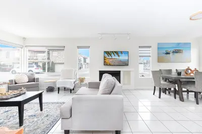 a living room with white furniture and a fireplace at Luxury 4Br W Ac, Rooftop Deck, And Stunning Ocean Views By Beachview Rentals in Newport Beach