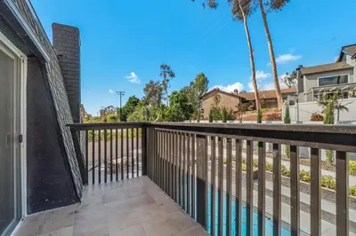 a balcony with a fence and palm trees at Hey I Am Adriana On The Block Pool BBQ in Mission Viejo