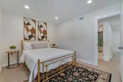 a white bedroom with a bed and a rug at Hey I Am Adriana On The Block Pool BBQ in Mission Viejo
