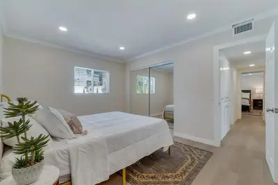 a white bedroom with a bed and a mirror at Hey I Am Adriana On The Block Pool BBQ in Mission Viejo