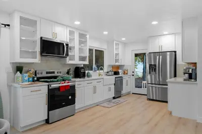 a large white kitchen with white cabinets and appliances at Entire Private Home with 4 Bedrooms 3 Bathrooms, Big Yard, View, , King Bed, 10 Parking, Available Now in El Cajon