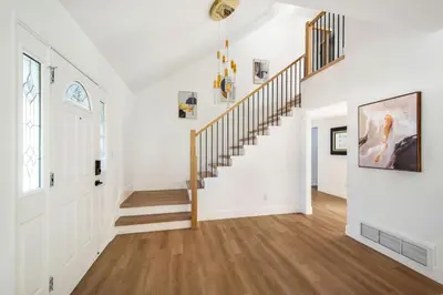 a hallway with white walls and a staircase with wood floors at Lux MV Home Live Like A Local Backyard Oasis in Mission Viejo