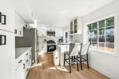 a kitchen with white cabinets and a table and chairs at Lux MV Home Live Like A Local Backyard Oasis in Mission Viejo