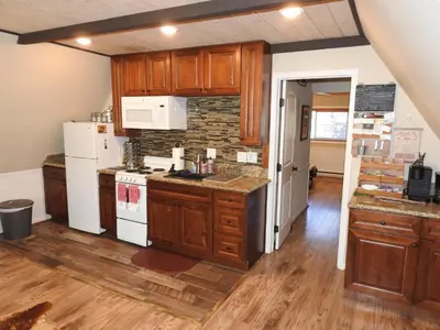 a kitchen with wooden cabinets and white appliances at Historic Gold Town Loft A-Frame 1 Bedroom with sofa sleeper WIFI in Julian
