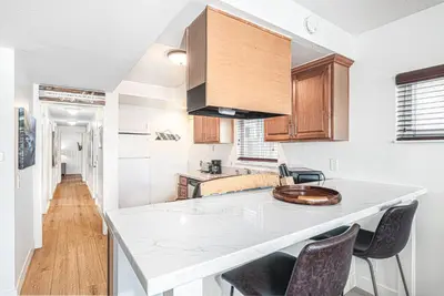 a kitchen with a white counter top and wooden cabinets at 4Br Retreat One House From The Beach And Boardwalk By Beachview Rentals in Newport Beach