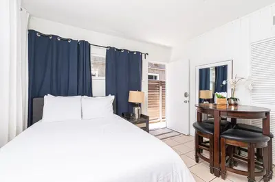 a bedroom with a bed and a table and a desk at 4Br Retreat One House From The Beach And Boardwalk By Beachview Rentals in Newport Beach