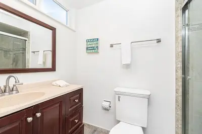 a bathroom with a toilet and a sink and a mirror at 4Br Retreat One House From The Beach And Boardwalk By Beachview Rentals in Newport Beach
