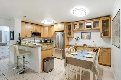 a kitchen with a table and a refrigerator at 1 Mi to PB Boardwalk Condo with Community Perks in San Diego