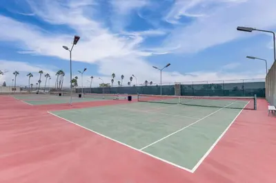 a tennis court with two tennis nets on it at 1 Mi to PB Boardwalk Condo with Community Perks in San Diego