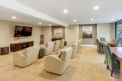 a conference room with chairs and a table and a television at 1 Mi to PB Boardwalk Condo with Community Perks in San Diego