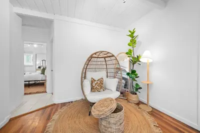 a living room with a rattan chair and a table at Modern Eclectic 2BR Near Petco, Balboa Park & Zoo in San Diego