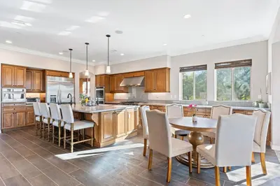 a kitchen with wooden cabinets and a table and chairs at Vineyard Vista Retreat in Temecula